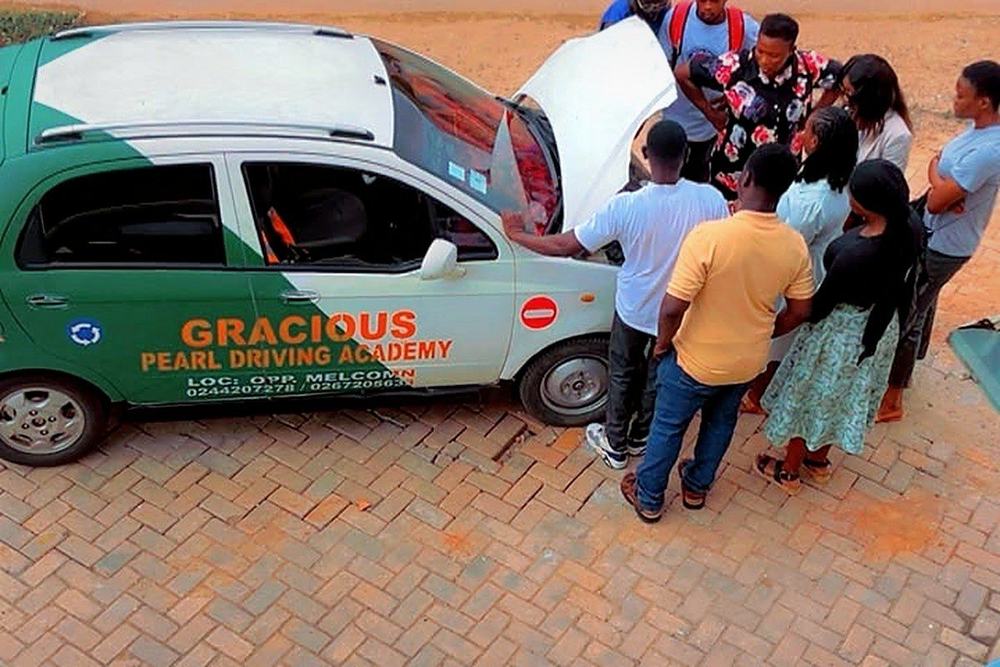 Students gathered around a training car with an instructor